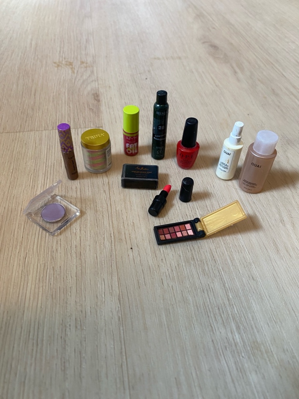 OUAI Pink Bottle with Red Nail Polish and Purple Eyeshadow Makeup Collection